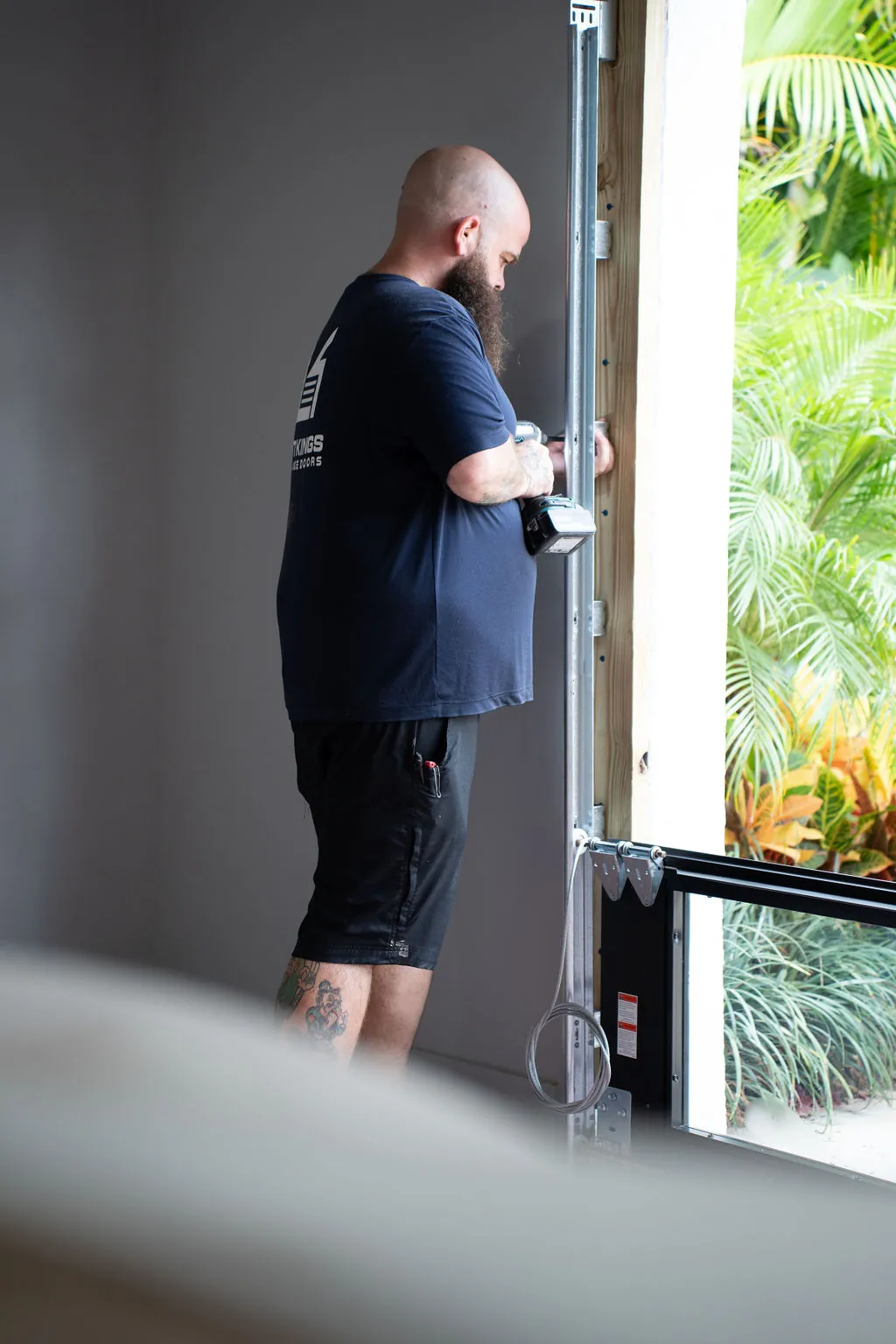Lift Kings installer mounting a hurricane-rated impact door on a Palm Beach County home